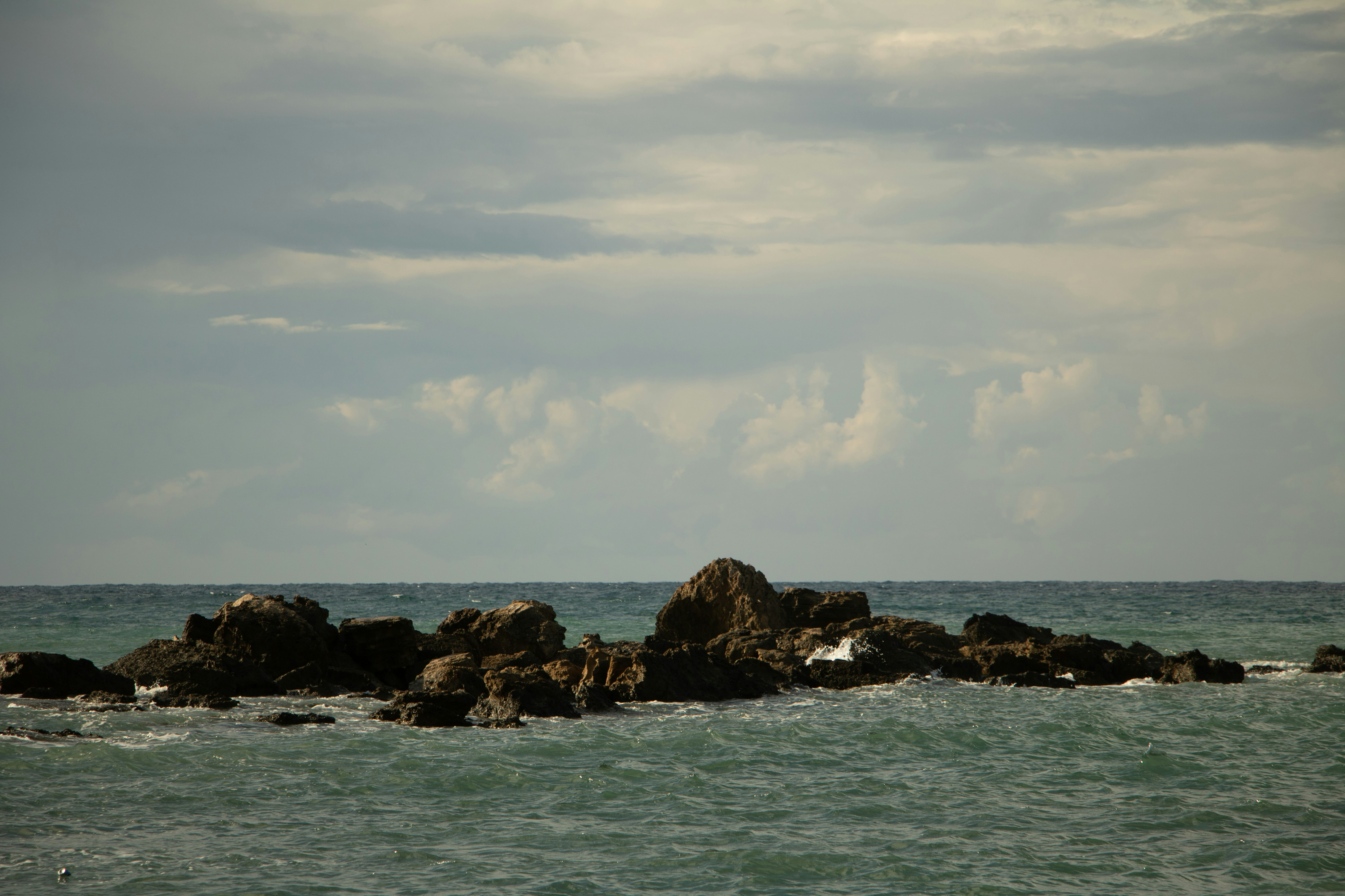 ヘルメットを被り、汗を拭いながらも充実した表情で休憩している作業員の写真