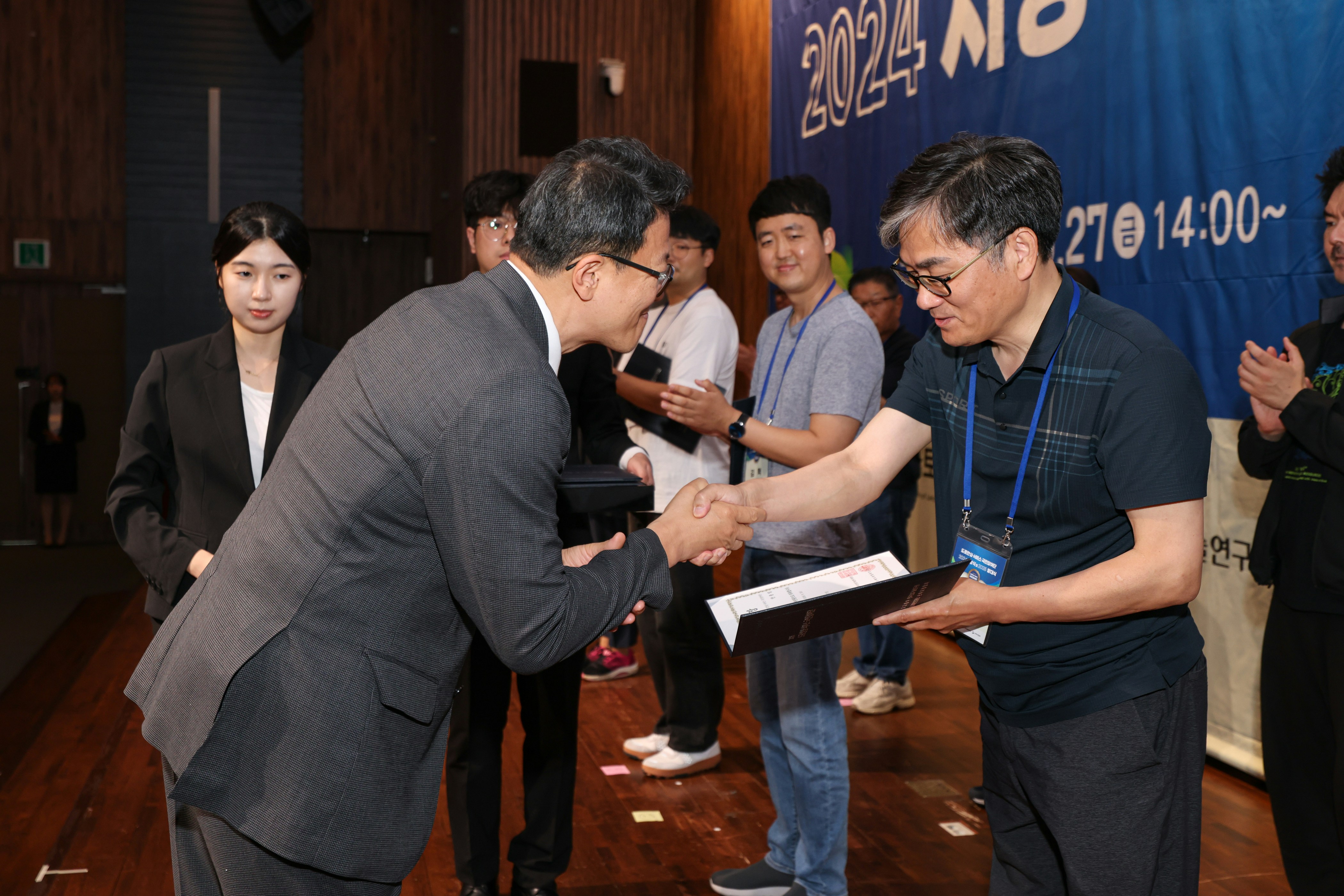 休憩時間にストレッチをしている人物（椅子に座ってできるものが望ましい）