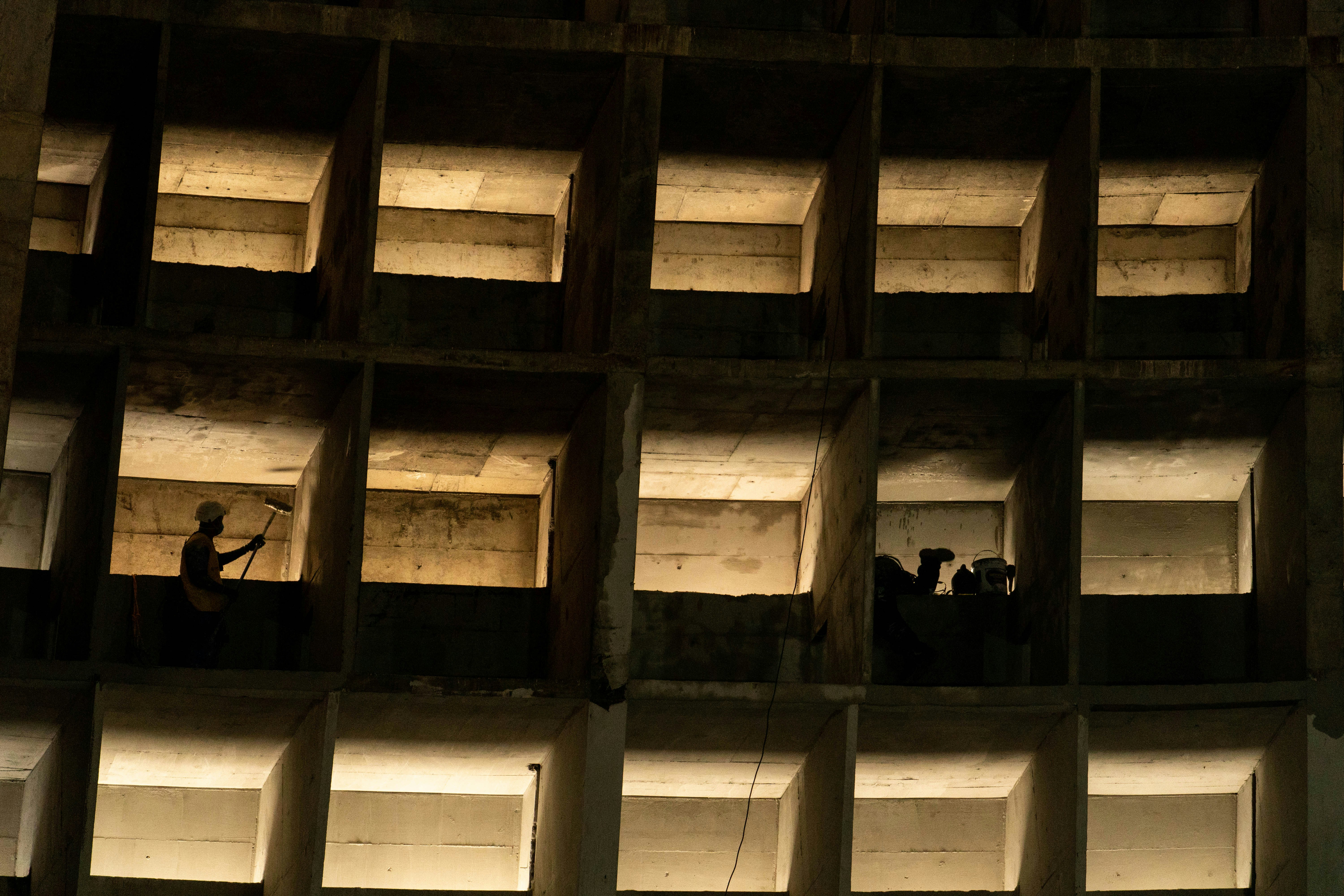 新しい建設現場で、若い世代の作業員がベテラン作業員から指導を受けている様子の写真